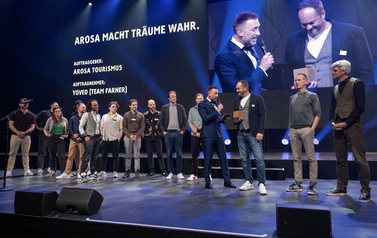 Jubel in «The Hall» für das Team «Arosa macht Träume wahr»: Moderator Marco Fritsche übergibt die Gold-Auszeichnung...    (Bild zVg)