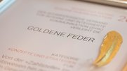 Die Goldene Feder im Rahmen und als Bild: Macht sich schön im Büro...(Bild: zVg)