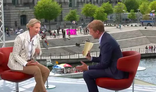 Das Open-Air-Interview wurde mit lauter Musik überschallt... (Bild: Screenshot ARD)